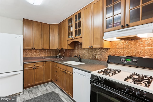 9039 Sligo Creek Pkwy Unit 102, Silver Spring, MD 20901 - kitchen with white appliances, under cabinet range hood, a sink, brown cabinets, and glass insert cabinets