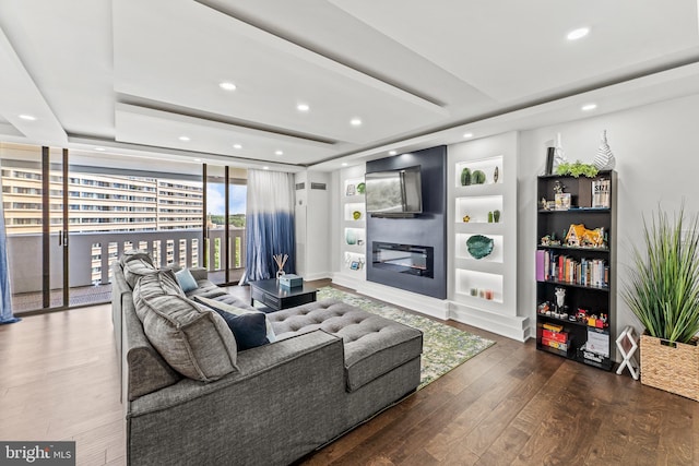 6101 Edsall Rd Unit 1111, Alexandria, VA 22304 - living area featuring wood finished floors, recessed lighting, a glass covered fireplace, a tray ceiling, and built in features