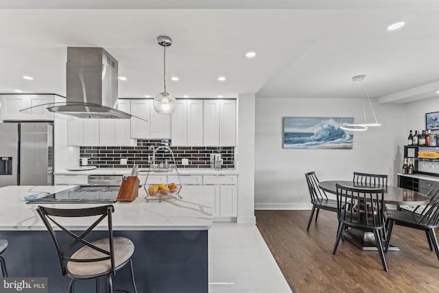 6101 Edsall Rd Unit 1111, Alexandria, VA 22304 - kitchen featuring island exhaust hood, white cabinetry, tasteful backsplash, stainless steel fridge, and light stone countertops