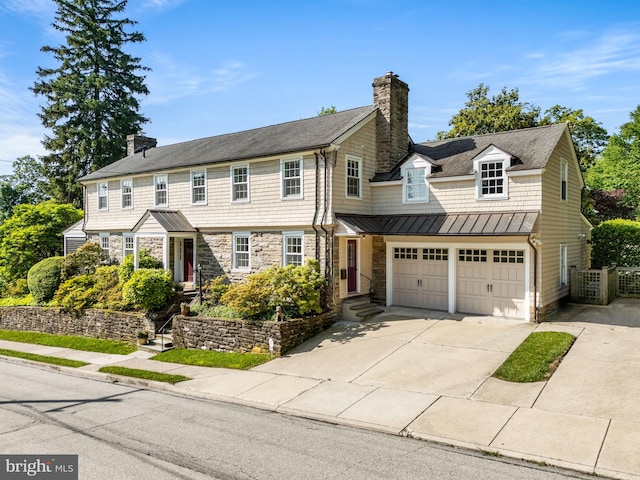 7700 E Ln, Wyndmoor, PA 19038 - view of front facade with a chimney, a standing seam roof, concrete driveway, and stone siding