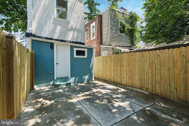 1910 E Atlantic St, Philadelphia, PA 19134 - view of side of home with stucco siding, a patio, and a fenced backyard