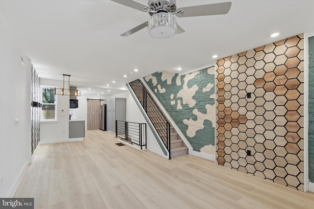 1910 E Atlantic St, Philadelphia, PA 19134 - unfurnished living room with a barn door, recessed lighting, an accent wall, light wood-style flooring, and ceiling fan