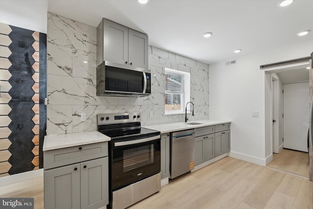 1910 E Atlantic St, Philadelphia, PA 19134 - kitchen with appliances with stainless steel finishes, a sink, gray cabinets, recessed lighting, and tasteful backsplash