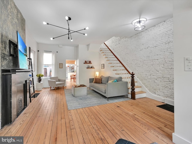 142 E New St, Lancaster, PA 17602 - living room with stairs, a large fireplace, wood-type flooring, and a chandelier