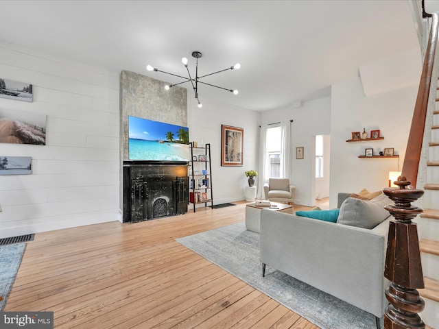 142 E New St, Lancaster, PA 17602 - living area with a fireplace, stairway, wood-type flooring, a chandelier, and wooden walls
