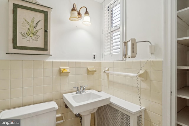 1901 Walnut St Unit 16E, Philadelphia, PA 19103 - bathroom featuring toilet, tile walls, wainscoting, and a sink
