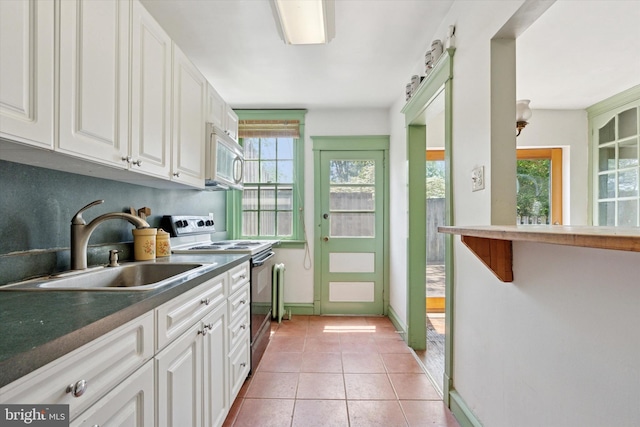 340 W Durham St, Philadelphia, PA 19119 - kitchen featuring range with electric cooktop, white microwave, a sink, and healthy amount of natural light