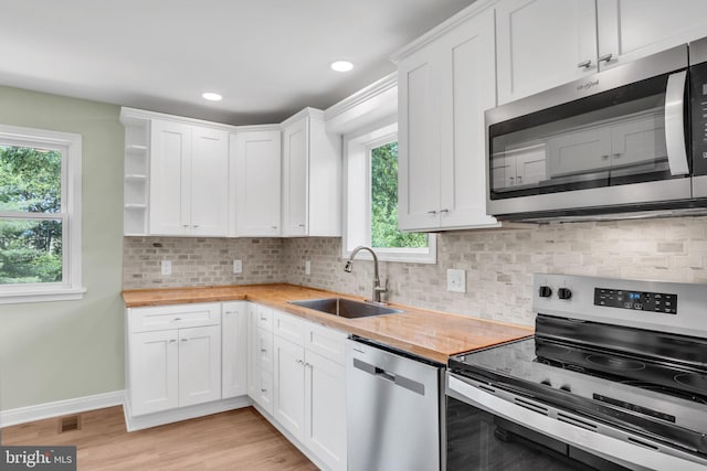 318 Mayfield Ct, Westminster, MD 21158 - kitchen featuring appliances with stainless steel finishes, a sink, butcher block counters, open shelves, and white cabinetry