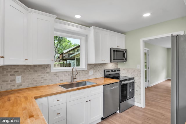 318 Mayfield Ct, Westminster, MD 21158 - kitchen featuring appliances with stainless steel finishes, butcher block countertops, a sink, backsplash, and light wood-type flooring