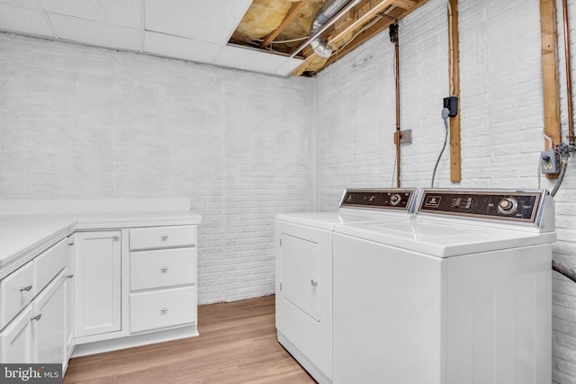 318 Mayfield Ct, Westminster, MD 21158 - laundry area featuring washing machine and clothes dryer, light wood finished floors, brick wall, and cabinet space