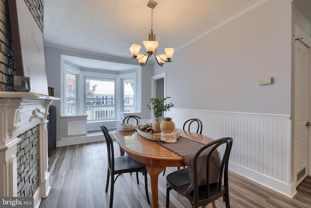 143 Hanover St, Glen Rock, PA 17327 - dining area with wood finished floors, a chandelier, a wainscoted wall, and a stone fireplace