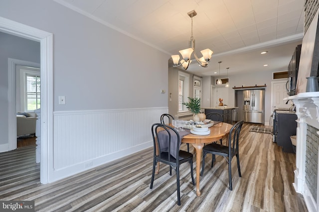 143 Hanover St, Glen Rock, PA 17327 - dining space featuring wood finished floors, a chandelier, wainscoting, ornamental molding, and a fireplace