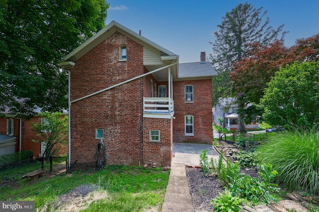 143 Hanover St, Glen Rock, PA 17327 - rear view of property featuring a balcony, a patio, brick siding, and a chimney