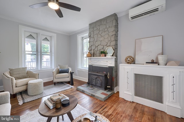 143 Hanover St, Glen Rock, PA 17327 - living area with an AC wall unit, a wood stove, crown molding, wood finished floors, and a ceiling fan