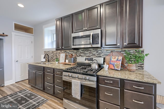 143 Hanover St, Glen Rock, PA 17327 - kitchen featuring appliances with stainless steel finishes, light wood-style floors, decorative backsplash, and a sink