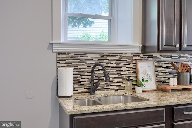 143 Hanover St, Glen Rock, PA 17327 - kitchen view of a sink, dark brown cabinetry, backsplash, and light stone counters