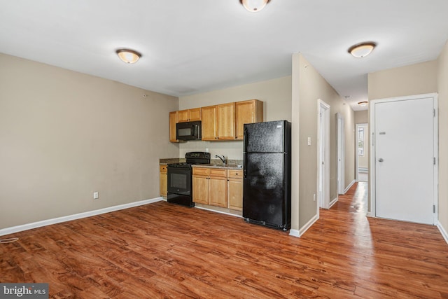 1718 N 55th St, Philadelphia, PA 19131 - kitchen with black appliances, wood finished floors, and baseboards