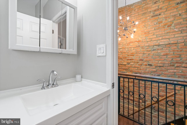 816 S Milton Ave, Baltimore, MD 21224 - bathroom with brick wall, vanity, and a chandelier