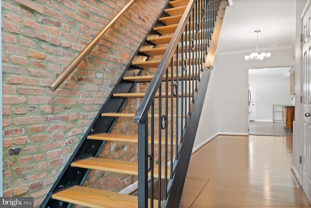 816 S Milton Ave, Baltimore, MD 21224 - stairs with baseboards, a chandelier, ornamental molding, brick wall, and wood finished floors