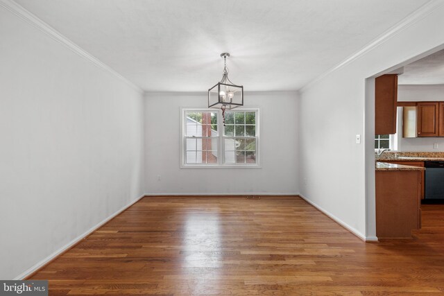 8321 Terra Grande Ave, Springfield, VA 22153 - unfurnished dining area with ornamental molding, a chandelier, wood finished floors, baseboards, and a sink