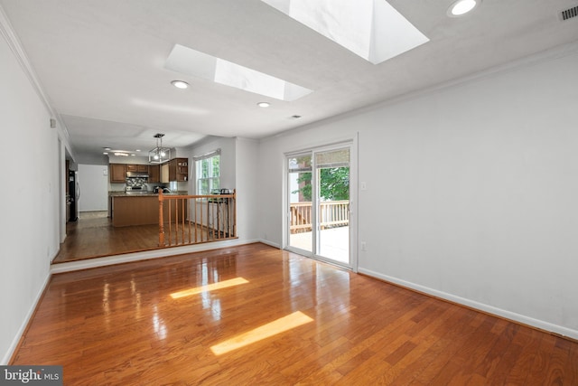 8321 Terra Grande Ave, Springfield, VA 22153 - unfurnished living room featuring a skylight, recessed lighting, ornamental molding, wood finished floors, and baseboards