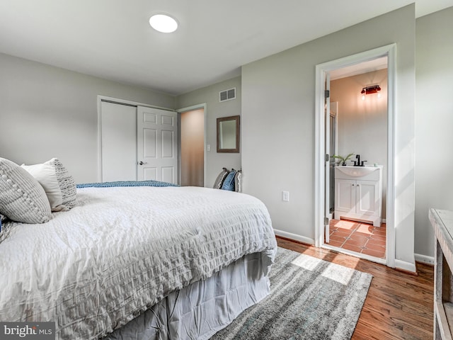 2411 Ruth Ave, Sparrows Point, MD 21219 - bedroom with a closet, wood finished floors, baseboards, and connected bathroom