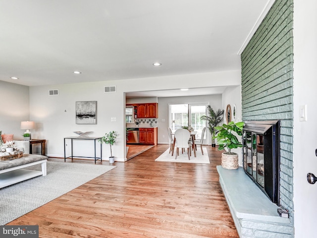 2411 Ruth Ave, Sparrows Point, MD 21219 - living room featuring light wood finished floors, recessed lighting, a brick fireplace, and baseboards