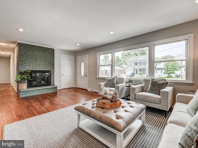 2411 Ruth Ave, Sparrows Point, MD 21219 - living room with wood finished floors, recessed lighting, baseboards, and a brick fireplace