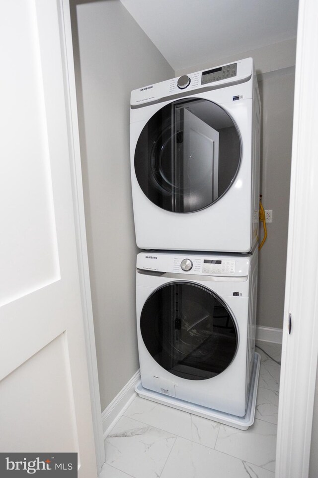 2127 Sigel St, Philadelphia, PA 19145 - laundry room featuring stacked washer and clothes dryer, marble look tiles, and baseboards