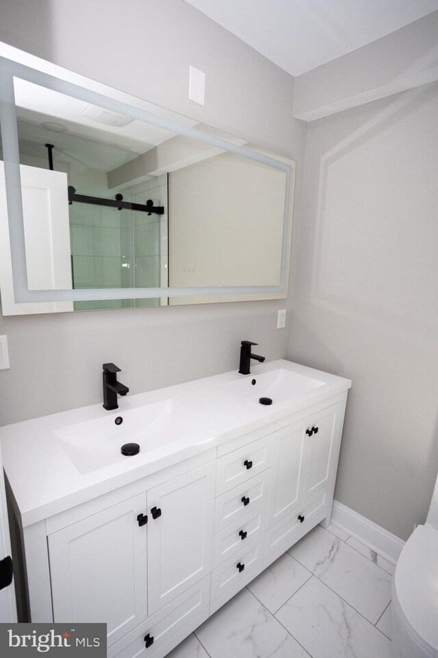 2127 Sigel St, Philadelphia, PA 19145 - bathroom featuring double vanity, marble look tile flooring, a shower with shower door, and toilet