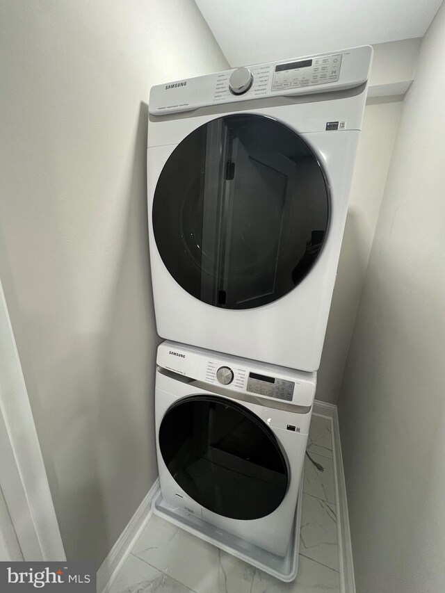 2127 Sigel St, Philadelphia, PA 19145 - laundry area with stacked washer / dryer, marble look tiles, and baseboards