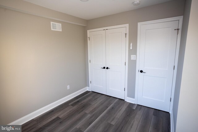 2127 Sigel St, Philadelphia, PA 19145 - unfurnished bedroom with dark wood-style flooring, baseboards, and a closet