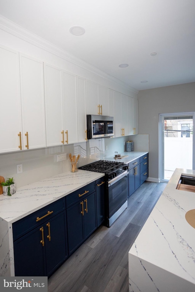 2127 Sigel St, Philadelphia, PA 19145 - kitchen with stainless steel microwave, range with gas cooktop, blue cabinetry, white cabinets, and wood finished floors
