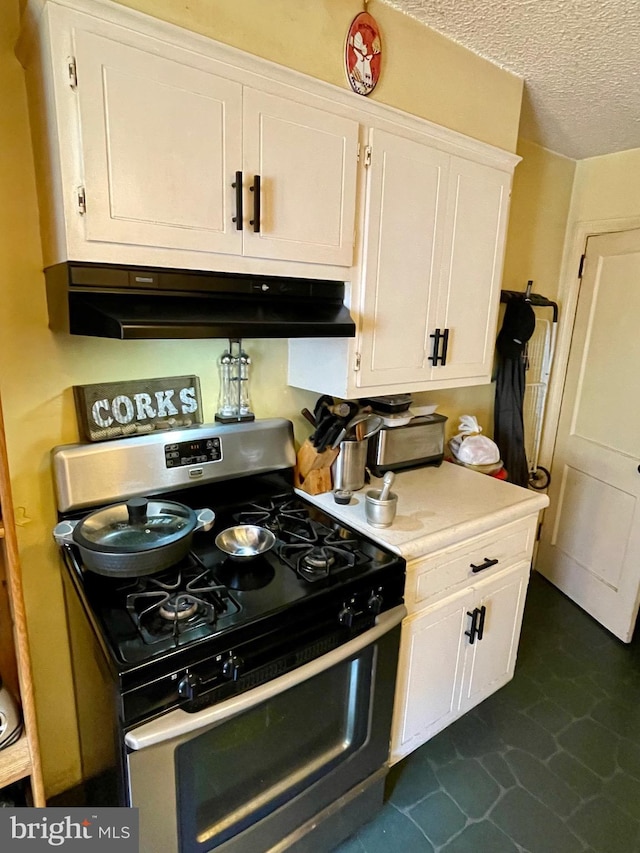 103 Willows Ave Unit 90, Norwood, PA 19074 - kitchen featuring stainless steel range with gas stovetop, under cabinet range hood, white cabinets, light countertops, and dark tile patterned flooring