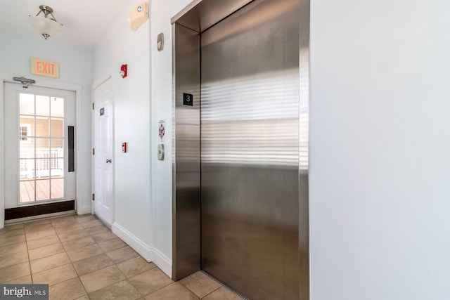 37685T Ulster Dr Unit 17, Rehoboth Beach, DE 19971 - hallway featuring elevator, light tile patterned flooring, and baseboards