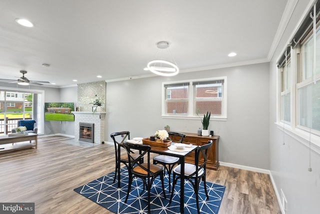 5634 Inverchapel Rd, Springfield, VA 22151 - dining space with baseboards, wood finished floors, a brick fireplace, ornamental molding, and recessed lighting