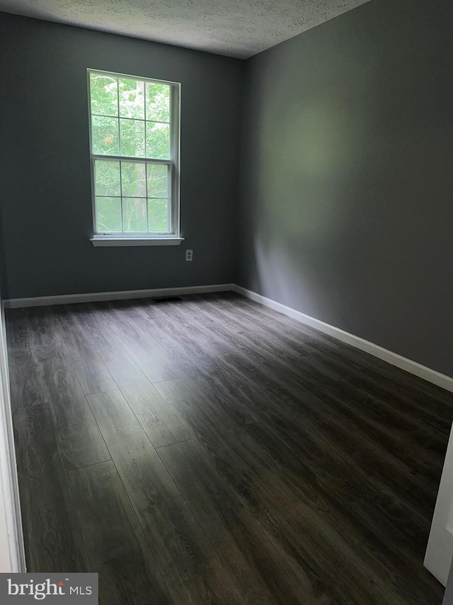 11429 Honeysuckle Ct Unit 3-3, Upper Marlboro, MD 20774 - unfurnished room featuring a textured ceiling, dark wood-style flooring, and baseboards