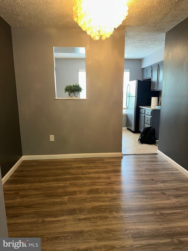 11429 Honeysuckle Ct Unit 3-3, Upper Marlboro, MD 20774 - unfurnished room featuring a textured ceiling, wood finished floors, a chandelier, and baseboards