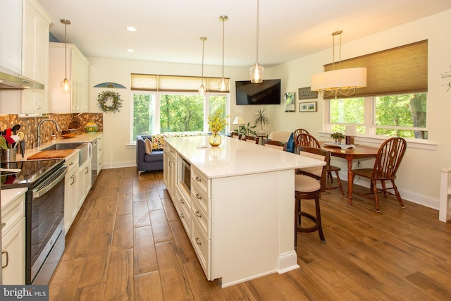312 E 7th Ave, Trappe, PA 19426 - kitchen with electric range, wood finished floors, a breakfast bar, healthy amount of natural light, and recessed lighting