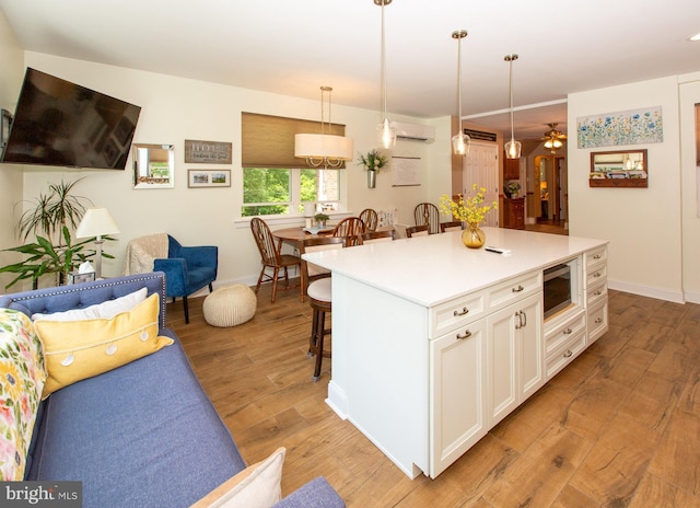 312 E 7th Ave, Trappe, PA 19426 - kitchen with built in microwave, a kitchen bar, light wood-style floors, white cabinets, and baseboards