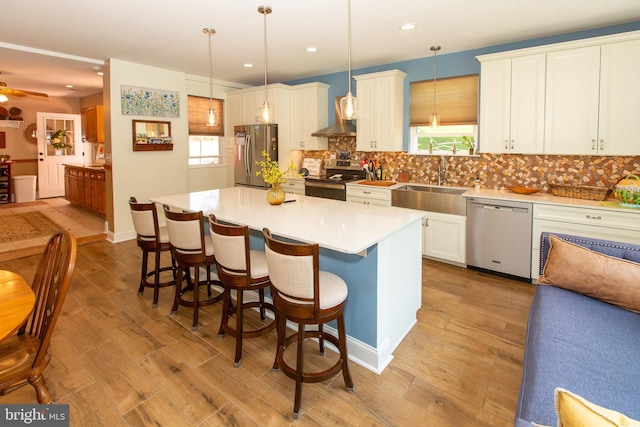312 E 7th Ave, Trappe, PA 19426 - kitchen with stainless steel appliances, a sink, a kitchen bar, light countertops, and wood finished floors