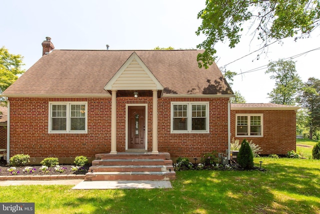 312 E 7th Ave, Trappe, PA 19426 - view of front of house with brick siding, a chimney, a front yard, and roof with shingles