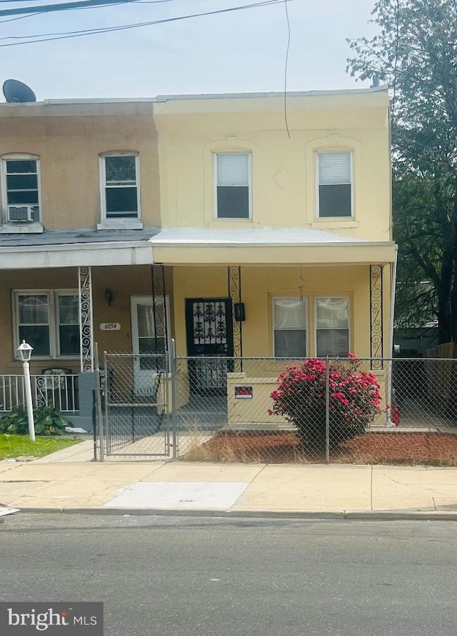 6056 Callowhill St, Philadelphia, PA 19151 - townhome / multi-family property with stucco siding, a porch, and a gate