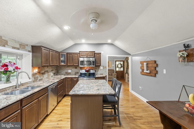 171 Sinking Spring Ln, Gore, VA 22637 - kitchen with stainless steel appliances, vaulted ceiling, a kitchen bar, ceiling fan, and light wood finished floors