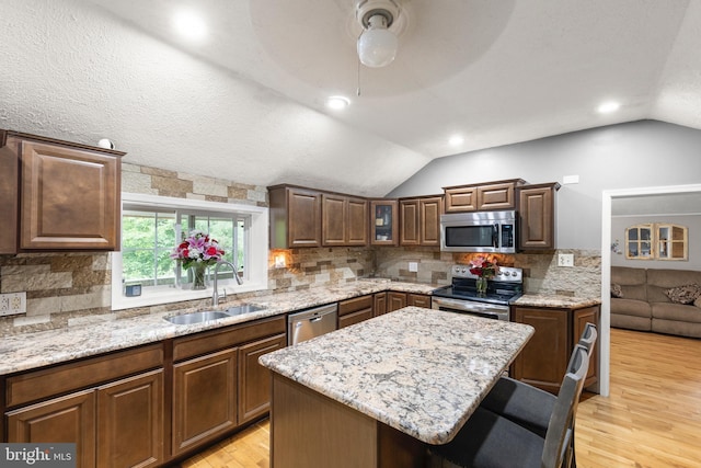 171 Sinking Spring Ln, Gore, VA 22637 - kitchen with stainless steel appliances, vaulted ceiling, light wood-type flooring, light stone countertops, and tasteful backsplash