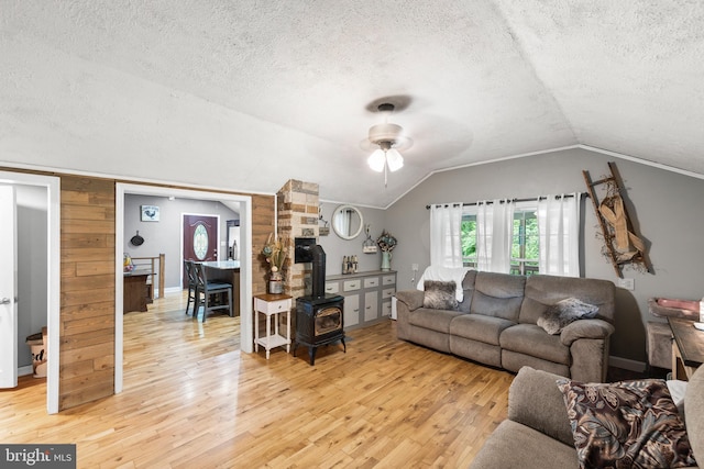 171 Sinking Spring Ln, Gore, VA 22637 - living room featuring a wood stove, light wood-style flooring, a textured ceiling, ceiling fan, and lofted ceiling