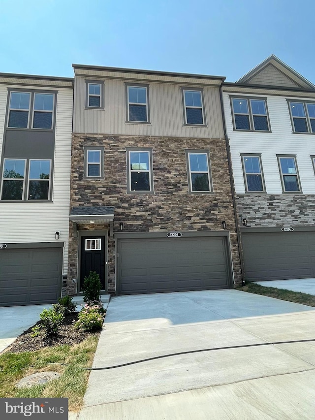 13206 Nixon Ln, Woodbridge, VA 22193 - townhome / multi-family property featuring stone siding, concrete driveway, an attached garage, and board and batten siding