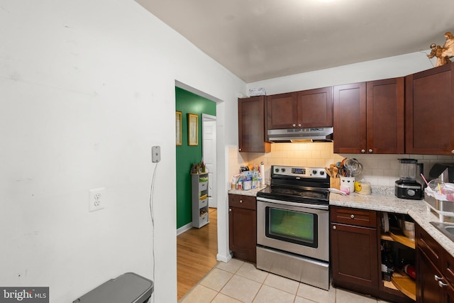 320 Lee St, Front Royal, VA 22630 - kitchen with stainless steel electric stove, under cabinet range hood, backsplash, and light tile patterned floors