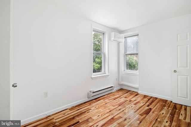 3545 Emerald St, Philadelphia, PA 19134 - unfurnished room with a baseboard radiator, a wall mounted AC, light wood finished floors, and baseboards