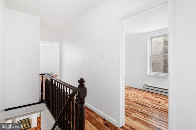 3545 Emerald St, Philadelphia, PA 19134 - hallway featuring an upstairs landing, a baseboard heating unit, wood finished floors, and baseboards